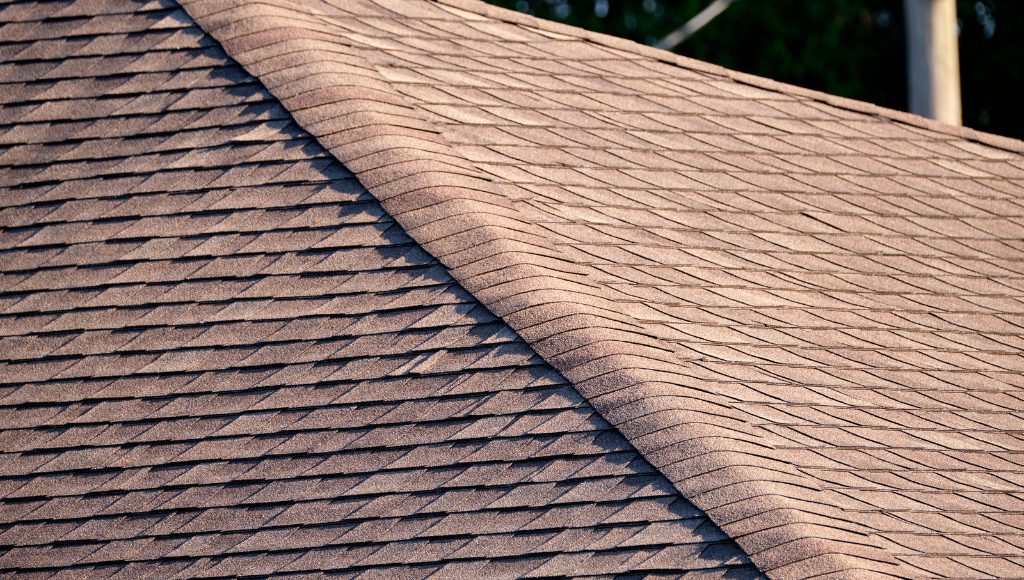 Close up of the ridge of a roof with asphalt shingles.