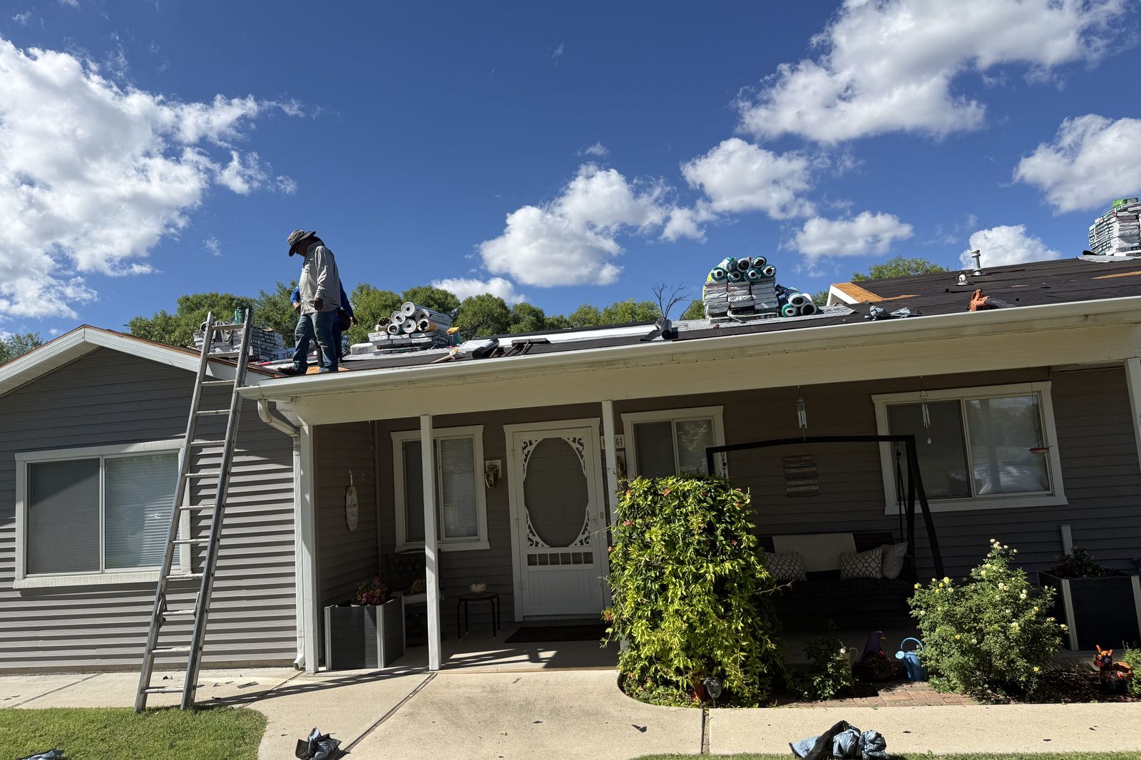 Roofer on ladder Enviro Pro roofer on a ladder during a residential roof replacement